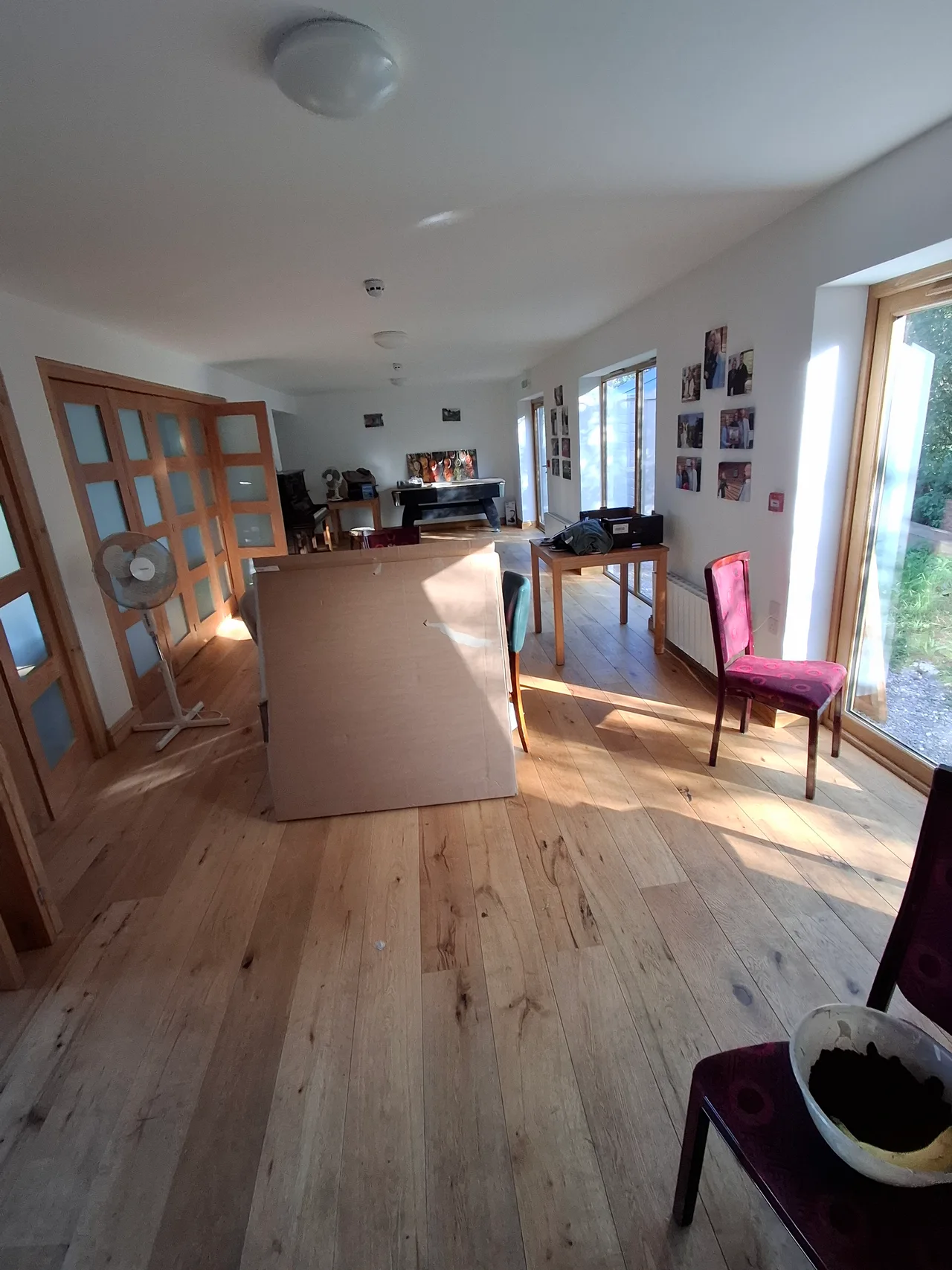 The Centre activities room with folding partitions, wooden flooring, courtyard windows and games equipment