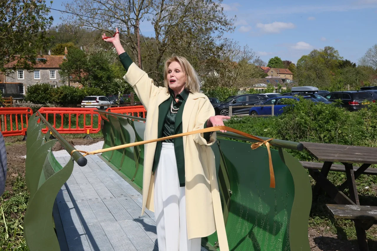 Dame Joanna Lumley standing on the green footbridge with a ribbon across it at the opening celebrations