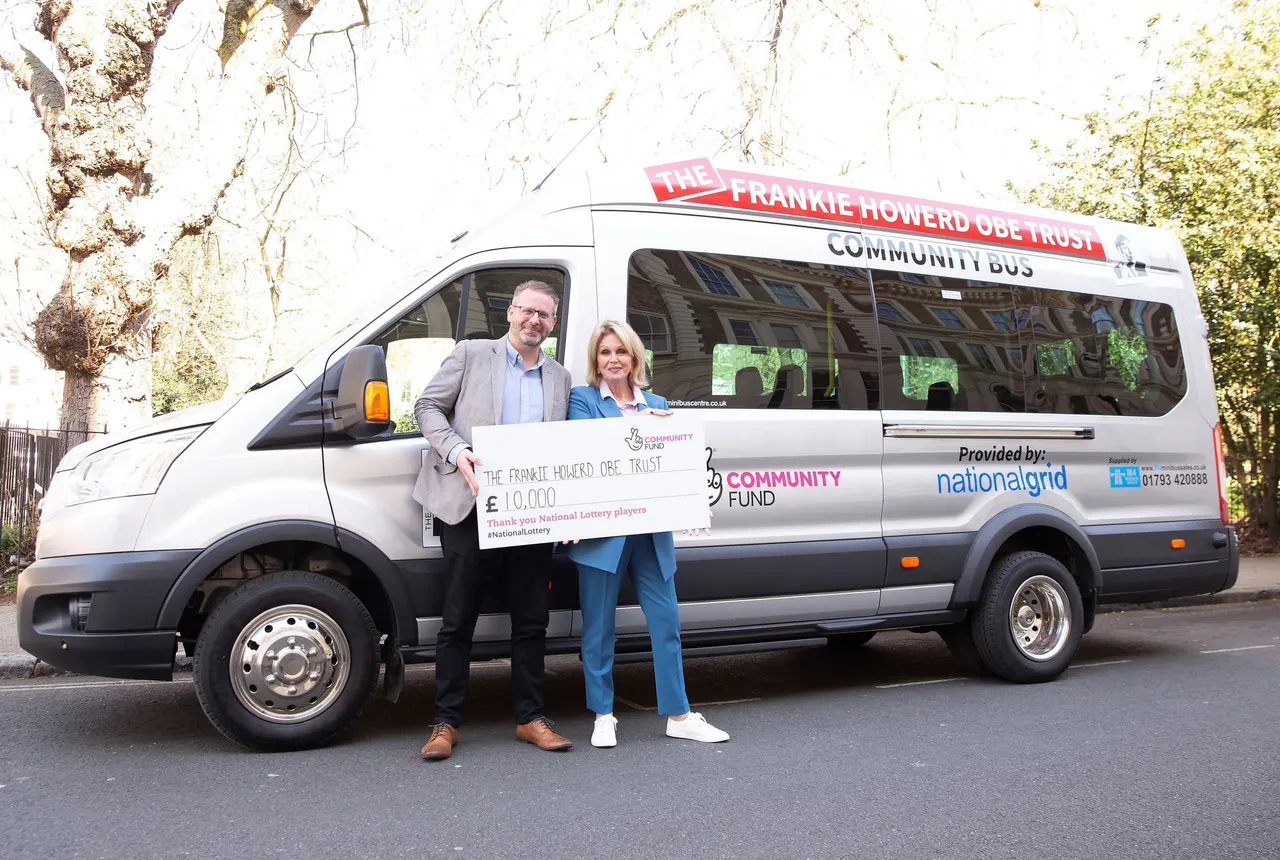 Dame Joanna Lumley and Phil Chamberlain holding a National Lottery cheque beside the Trust’s minibus
